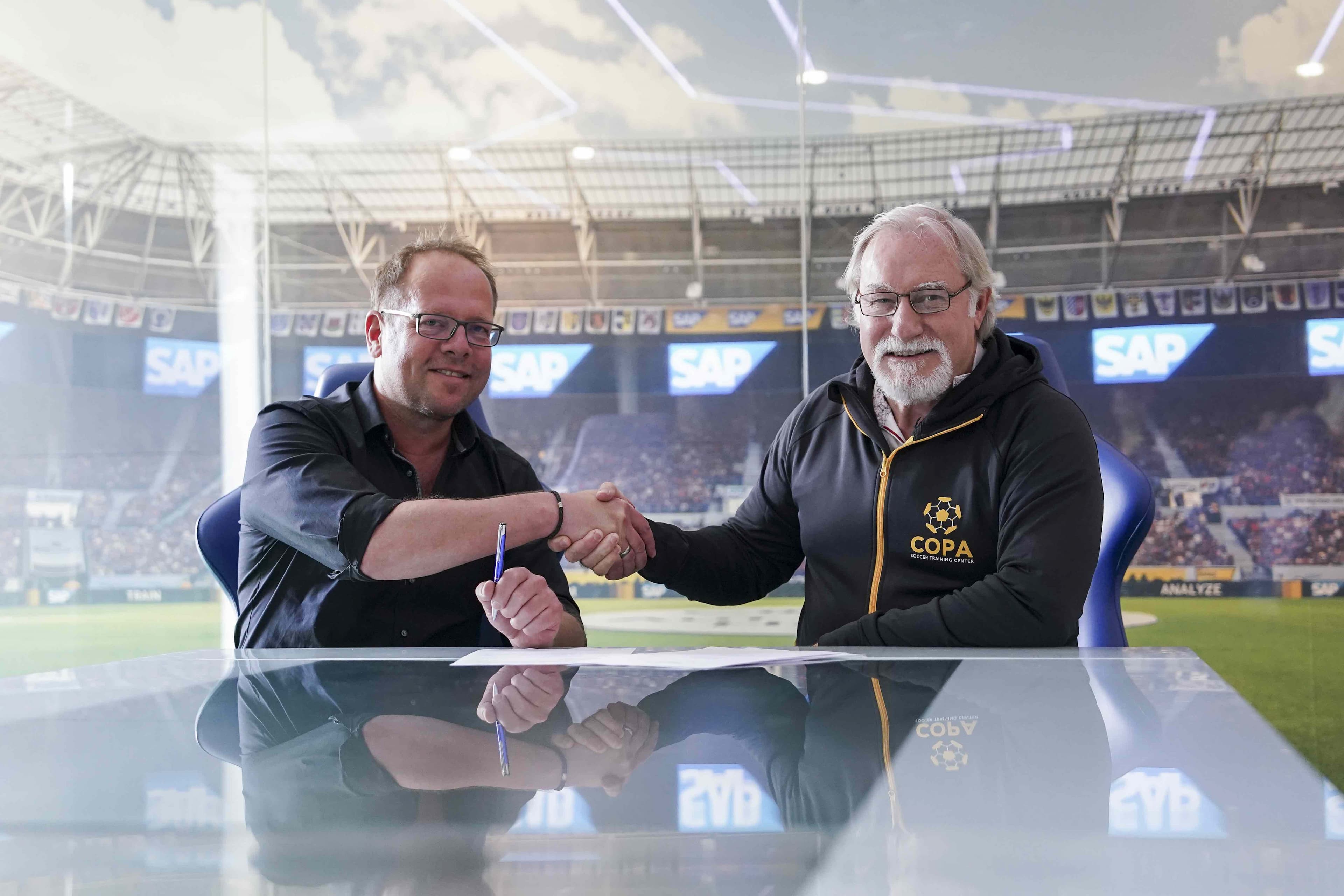 TSG-Geschäftsführer Jan Mayer (l.) bei der Vertragsunterzeichnung mit Mark Hall, COPA-CEO (r.): „Wir haben uns in den vergangenen Jahren konsequent zum Innovationsführer im deutschen Fußball entwickelt.“ (Foto: TSG Hoffenheim)
